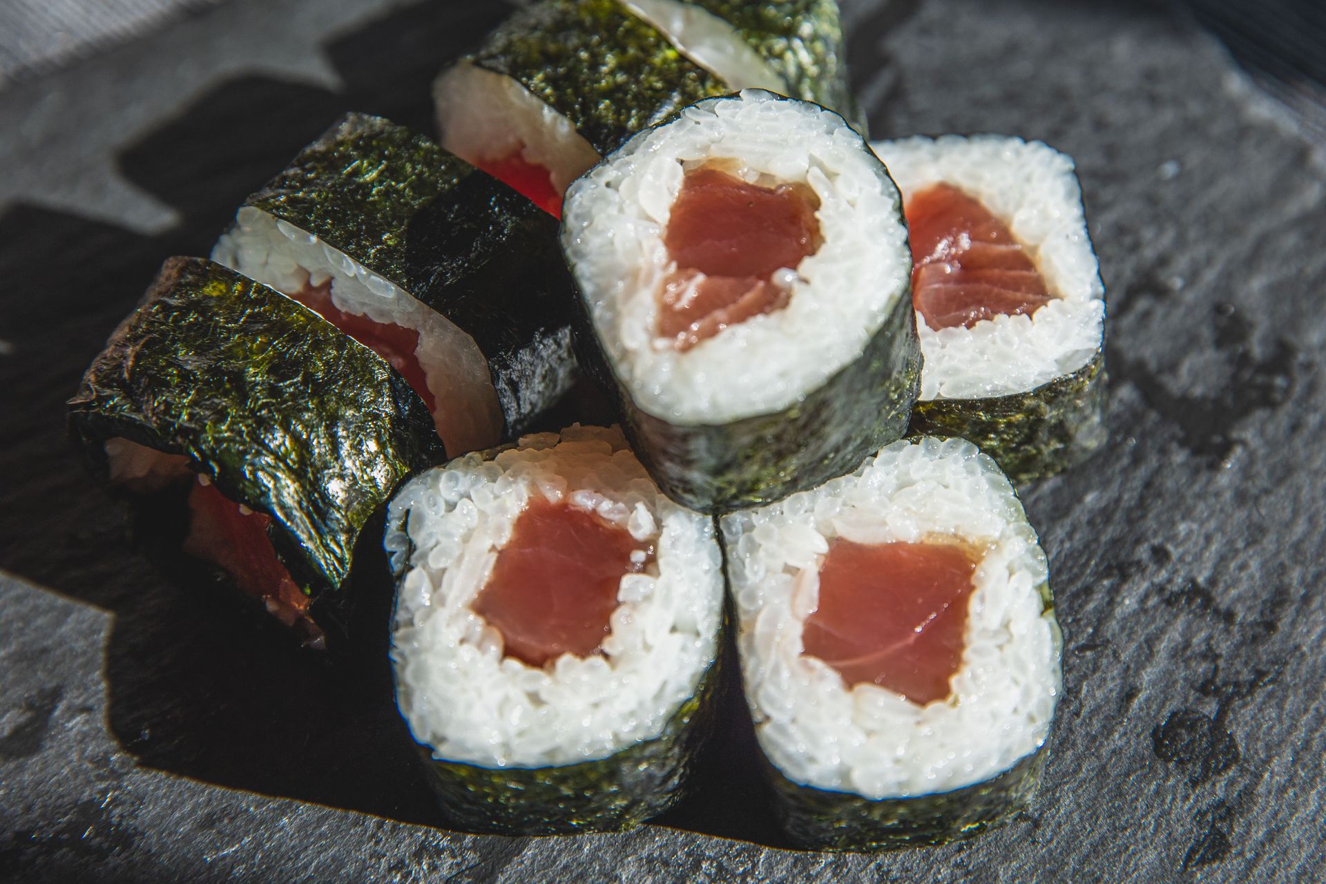 From above of delicious fresh rolls with rice and raw tuna rolled up with green seaweed